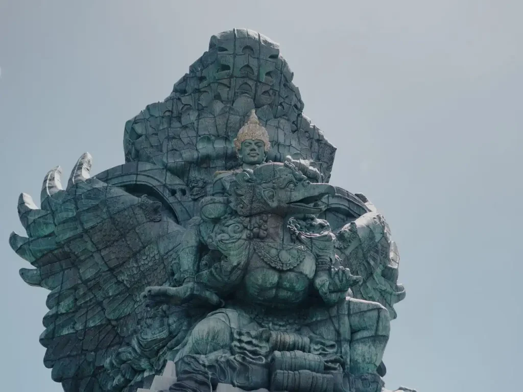 Close-up shot of the detailed copper and brass Garuda Wisnu Kencana Statue in Bali, depicting Hindu deity Vishnu riding the mythical bird Garuda.